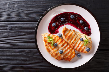 Dietary delicious food: Grilled chicken fillet with blueberry sauce and mint closeup. Horizontal top view