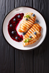 Dietary delicious food: Grilled chicken fillet with blueberry sauce and mint closeup. Vertical top view