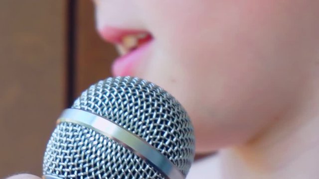 child's mouth sings into the microphone.close-up