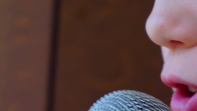 child's mouth sings into the microphone.close-up