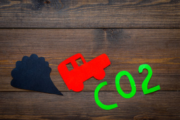 Car exhaust, co2, smoke. Car and smoke cutout on dark wooden background top view copy space