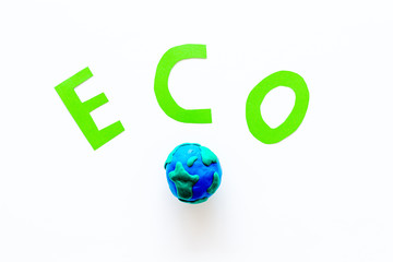 Eco icon cutout near planet Earth plastiline symbol on white background top view copy space