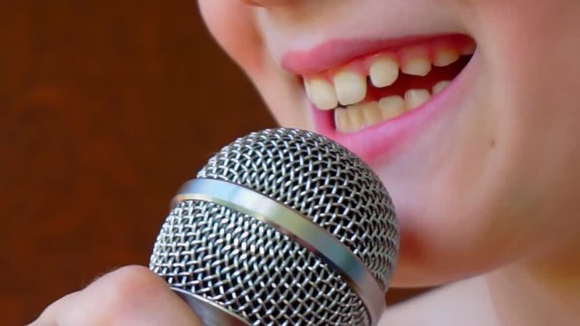 child's mouth sings into the microphone.close-up