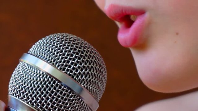 mouth of a child singing into a close-up microphone.