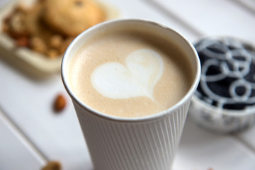 Cup of coffee on wood background with snacks