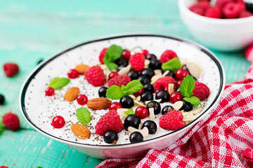Detox and healthy superfoods breakfast in bowl. Vegan almond milk chia seeds pudding with raspberries, blackberries and  mint.