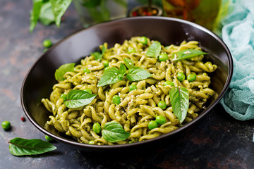 Fusilli pasta with  pesto sauce, green peas and basil. Italian food.