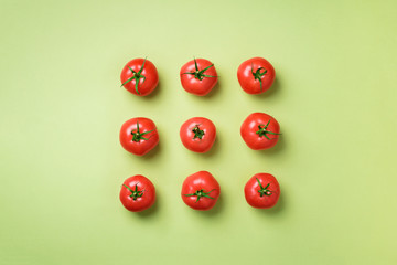 Creative pattern of red tomatos on green background. Top view. Copy space. Minimal design....