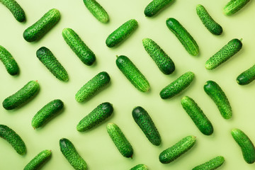 Creative pattern of fresh cucumbers on green background. Top view. Copy space. Minimal design. Vegetarian, vegan, organic food and alkaline meal concept