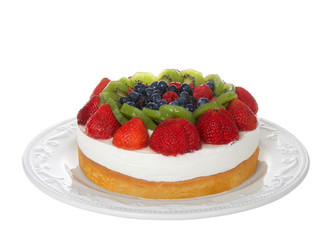 Fresh fruit on a shortbread cake with whipped cream topping on off white porcelain plate isolated on white. Focus stacked for greater depth of field.