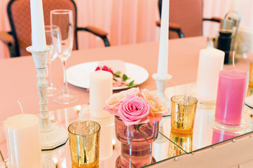 Decorative decoration of a festive wedding table with the help of mirrors and candles