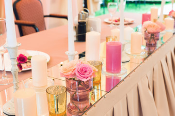 Decorative decoration of a festive wedding table with the help of mirrors and candles