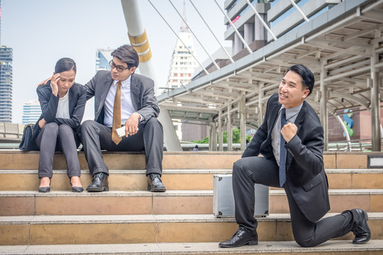 Young Happy Businessman Making Fun Of Sad Businessteam