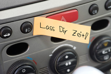 Fototapeta premium Eine Nachricht im Auto mit dem Text Lass Dir Zeit