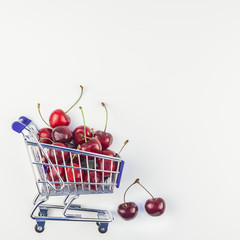 Ripe cherries in a shopping cart isolated