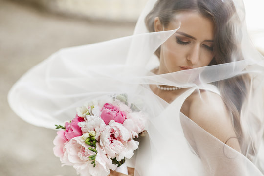 Pictures of stunning bride posing under the veil outside