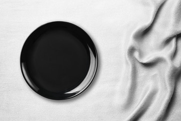 Black Empty Ceramic Plate on white tablecloth on table ,top view.