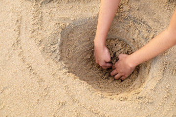 Girl Digging a Big Hole for Fun Playing at the Sea Beach Morning.