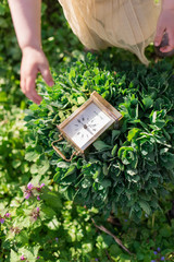 Girl plays with a clock on the green field