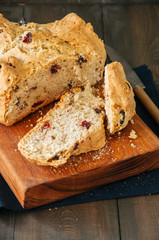 Irish soda bread with cranberries and raisins on wooden board. Close up.