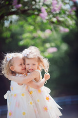 The twins girls  embracing in the park