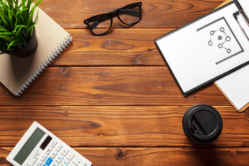 Top view of a dark wooden working table with office supplies