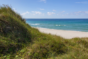 Sandy dunes covered with a grass on lovely Sola Strand beach near Stavanger, Norway