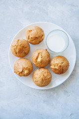 Gluten free almond flour muffins with apples and glass of milk in plate on a white stone background.