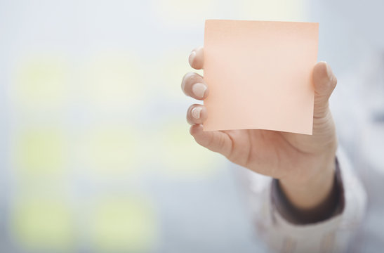 Hand Of Woman Holding Sticky Note With Empty Space