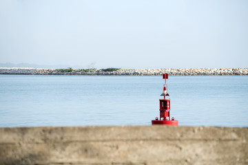 Navigation mark buoy red, floating in the morning sea