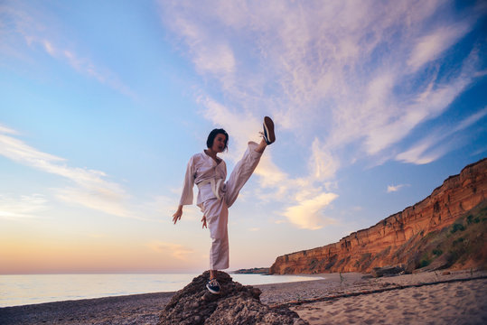 samurai in a kimono while training on the ocean coast, at sunrise. The concept of a healthy lifestyle, unity with nature, meditation.
