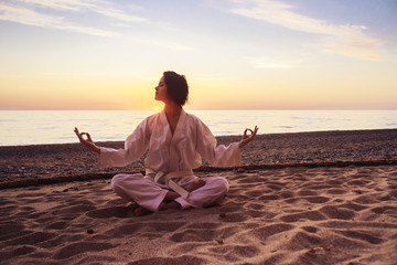 samurai in a kimono while training on the ocean coast, at sunrise. The concept of a healthy lifestyle, unity with nature, meditation.

