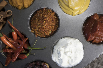 Soy sauce, balsamic sauce, pomegranate sauce, ketchup, sour cream, mustard, basil, pepper in kitchen utensils