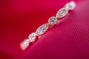Jewelry luxury pink gold ring with sapphire gemstone on red fabric texture background