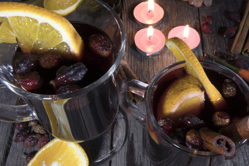 glasses of mulled wine with orange and cinnamon on a wooden background