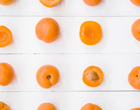 fresh apricot creative pattern in square on white wooden background with leaves flat lay top view