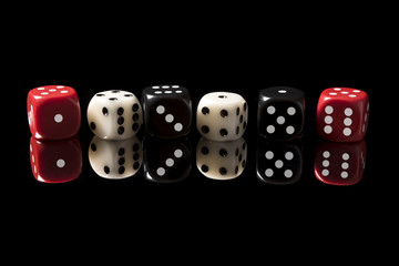 Game bones on a black surface with a reflection.