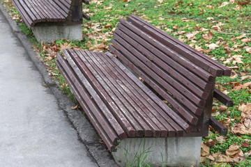 Public wooden bench with concrete on city street in the park