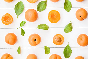 fresh apricot pattern on white wooden background with leaves flat lay top view