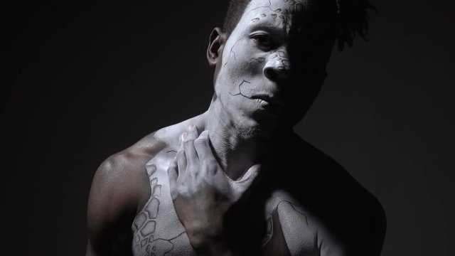 A guy in white body art shows his inner essence