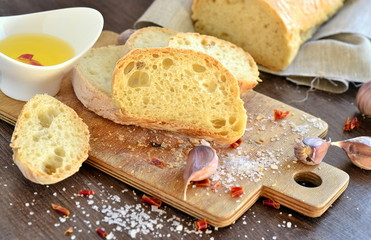 Fresh bread - ciabatta, chili and garlic on old wooden board