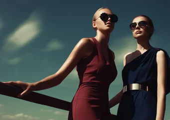 Zwei Models posieren vor dem Hintergrund des sonnigen Himmels © britanskiy