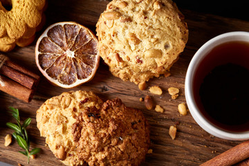 White cup of tea and cookies on a log over country style wooden background, close-up, selective focus