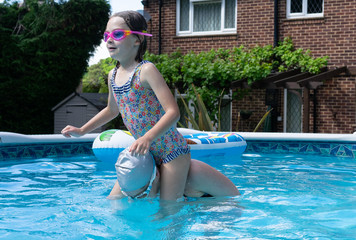 Mother and daughter in the swimming pool with daughter on shoulders about to be thrown in 