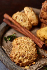 Obraz na płótnie Canvas Conceptual composition with assortment of cookies and cinnamon on a wooden barrel, selective focus, close-up