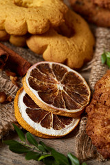 Conceptual composition with assortment of cookies and cinnamon on a wooden barrel, selective focus, close-up