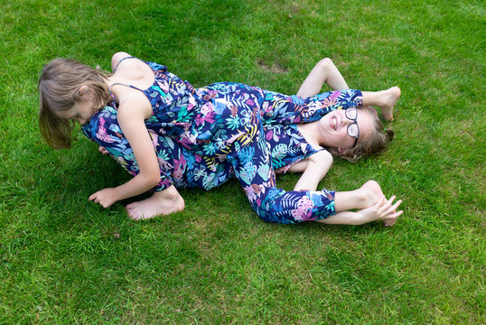 two sister on the grass playing and having fun
