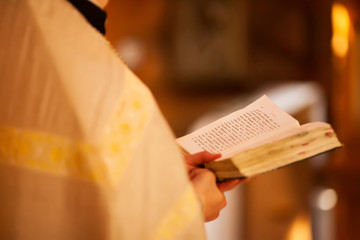 The orthodox priest in the church reading Holy Book, close up