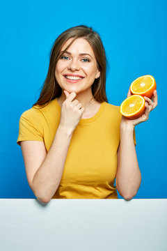 Cheerful girl holding two orange slices.