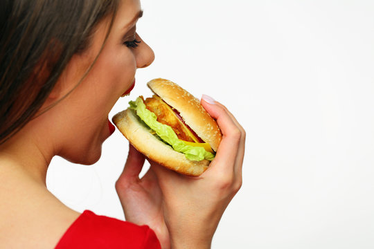 Girl standing back bites burger